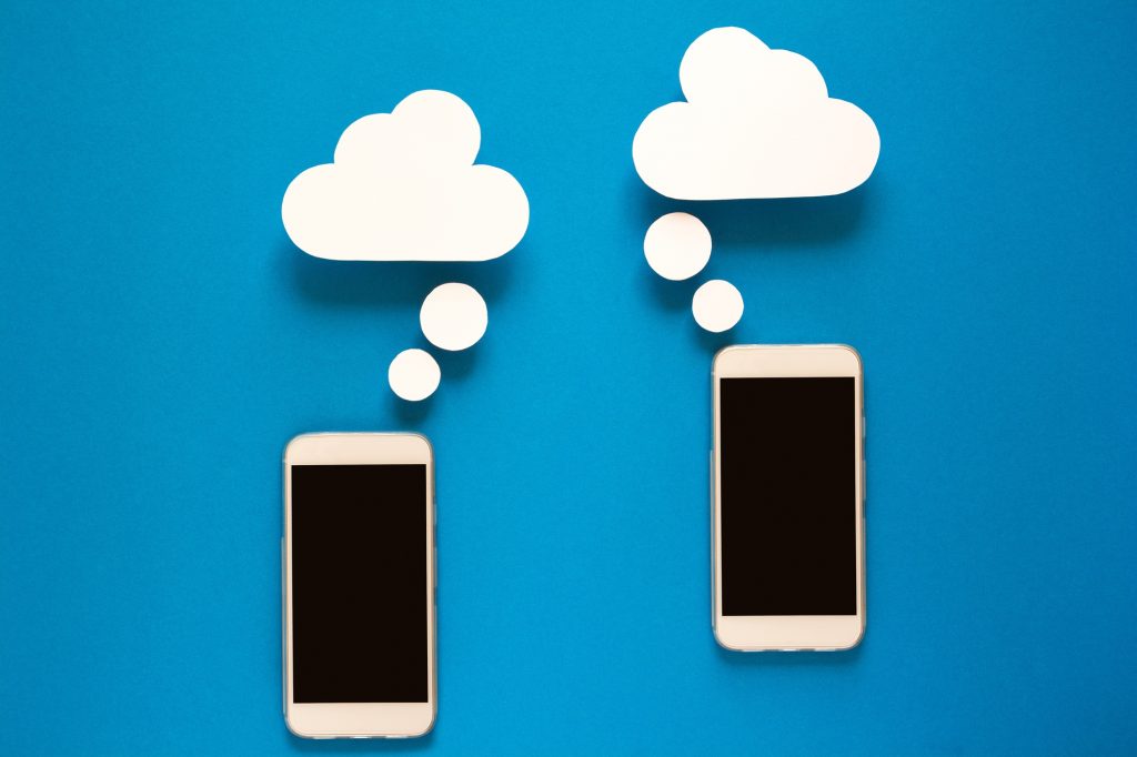 Smartphones with paper speech bubbles on blue background